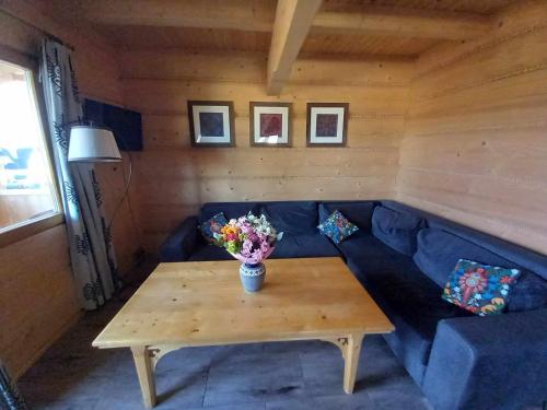 a living room with a blue couch and a table at Dom z widokiem na Wierchy - panorama na Tatry - Traditional folk house in Gliczarów Górny