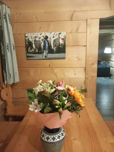 a vase of flowers sitting on a wooden table at Dom z widokiem na Wierchy - panorama na Tatry - Traditional folk house in Gliczarów Górny