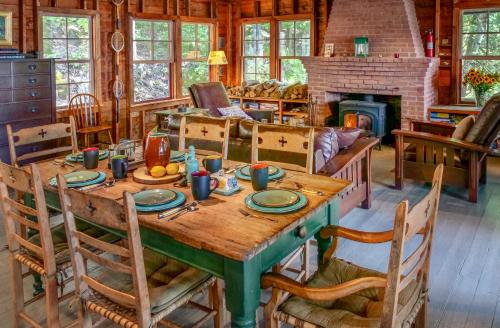 a dining room with a table and a fireplace at Finlays Cove on the Lake in Colchester