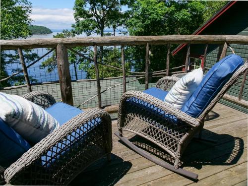 two wicker chairs with pillows sitting on a deck at Finlays Cove on the Lake in Colchester