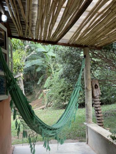 a hammock hanging from a pergola on a porch at Chalés Del'Minas in Passa Quatro