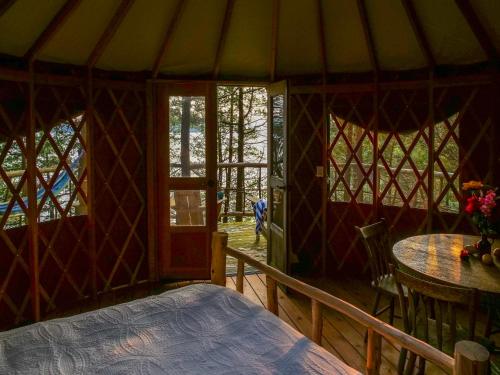 a room with a bed and a table in a yurt at Finlays Cove on the Lake in Colchester
