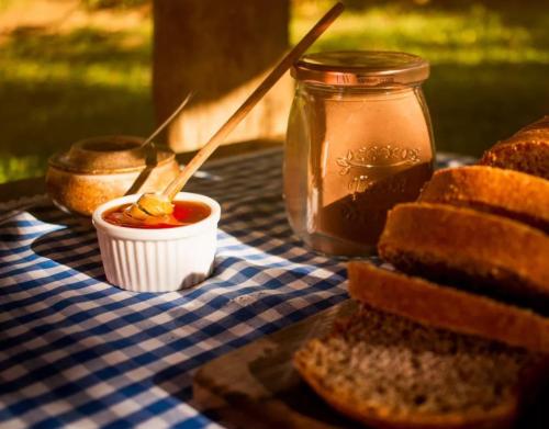 a table with bread and a jar of ketchup and a sandwich at Chalés Del'Minas in Passa Quatro