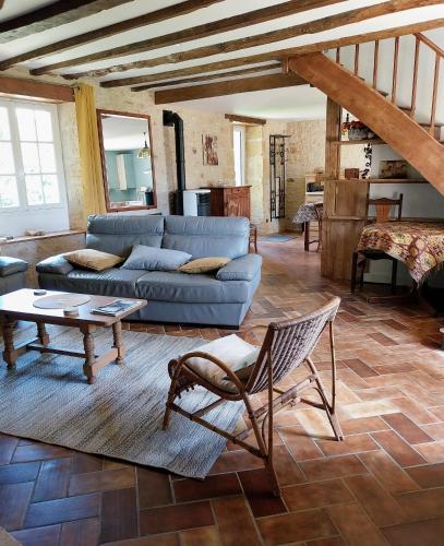 un salon avec un canapé et une table dans l'établissement La Geneste un gîte dans la campagne sarladaise, à Sainte-Nathalène