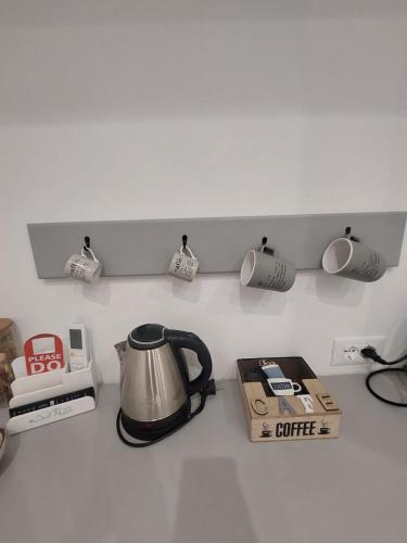 a kitchen counter with a coffee pot on a shelf at B&B A Due Passi in Ischia