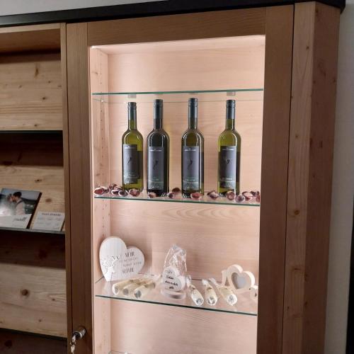 a cabinet with four bottles of wine in it at Pension Alpenfeeling in Pfronten