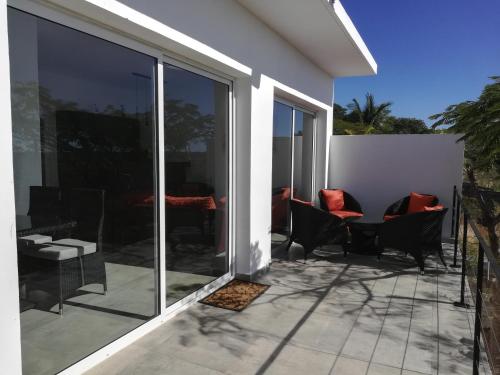 a patio with chairs and a table on a house at Résidence ÉBÈNE - Villas in Antsakomboena