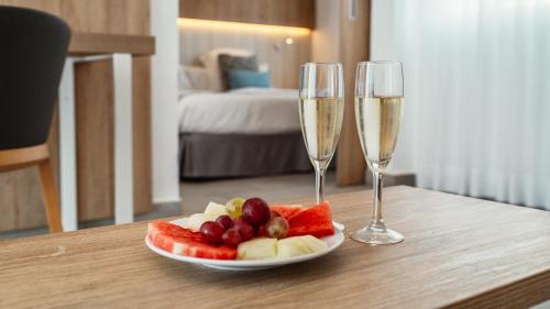 a plate of fruit and two champagne glasses on a table at Labranda Alyssa Suite Hotel in Playa Blanca