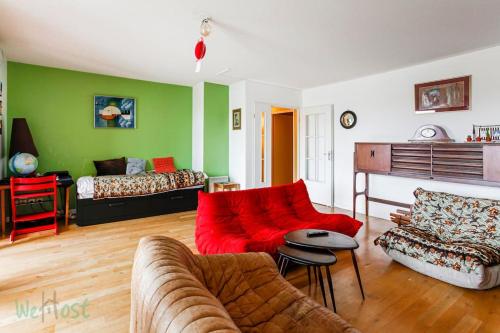 un salon avec un canapé rouge et des murs verts dans l'établissement Brunhes Toulouse - CI - Spacieux 3 chambres Pkg Métro St Cyprien, à Toulouse