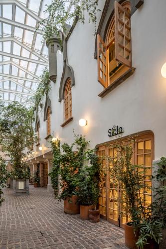 a shopping mall with potted plants and a glass ceiling at Hotel Parián in Mexico City