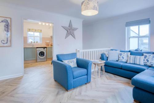 a living room with blue chairs and a blue couch at Kilmore House - 2 Bedroom Apartment - Tenby in Tenby