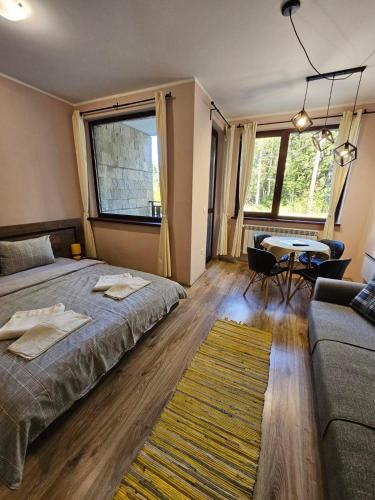 a bedroom with a bed and a couch and a table at BoroHome in Borovets