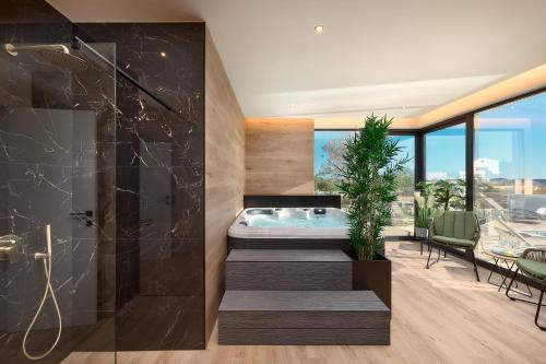 a bathroom with a soaking tub and a table and chairs at Villa Liliana Vodice in Vodice