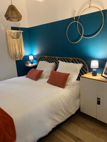 une chambre avec un grand lit blanc avec des murs bleus dans l'établissement Le Petit Vendôme avec terrasse, à Aix-en-Provence