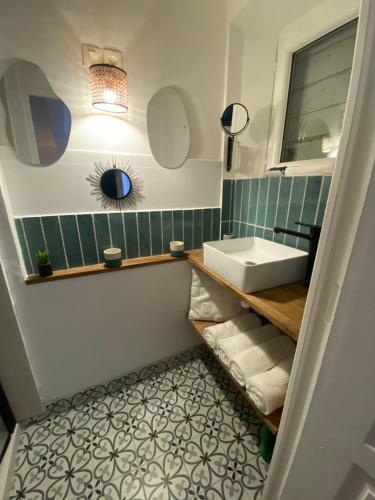 une salle de bain avec un lavabo et un miroir dans l'établissement Le Petit Vendôme avec terrasse, à Aix-en-Provence