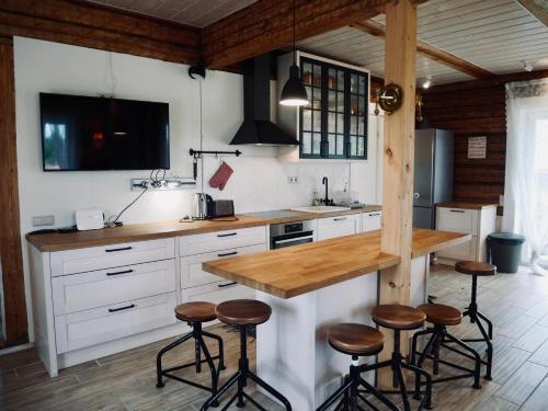 a kitchen with white cabinets and a counter with stools at Sportsmen´s Holiday House in Otepää