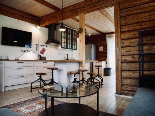 a kitchen with a glass table and some bar stools at Sportsmen´s Holiday House in Otepää