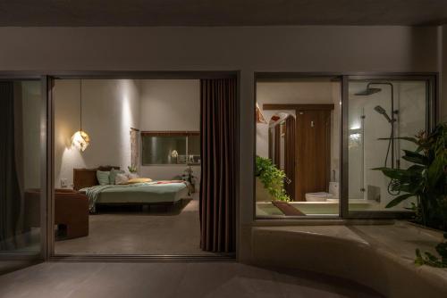 a view of a bedroom with a bed and a mirror at Camfusion House in Hoi An