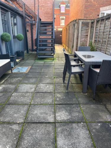 a patio with a table and chairs and a table and chairs at Cosy and Peaceful Maisonette with Terrace, Kidderminster in Kidderminster