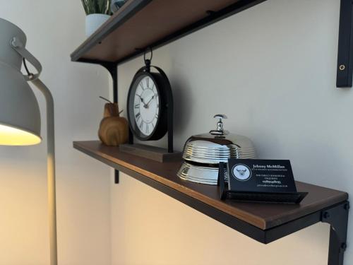a shelf with a clock and a book on it at 20a, By The Ness in Inverness