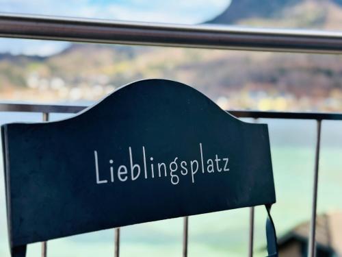 a black sign on a railing with the words volunteering spirit at Brunnwirt ESSEN & WOHNEN in Fuschl am See