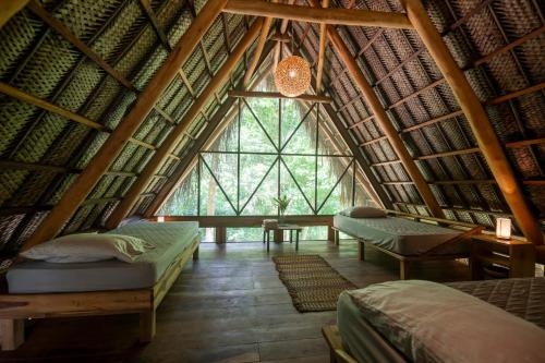 a room with two beds and a large window at Canto Tayrona Ecolodges in Buritaca