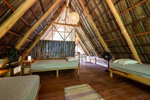 a room with two beds in a straw hut at Canto Tayrona Ecolodges in Buritaca