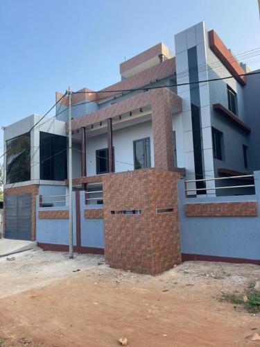 a house with a brick wall in front of it at Villa ORMACE in Lomé