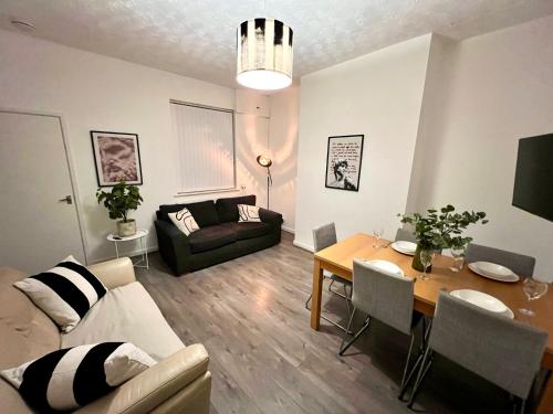 ein Wohnzimmer mit Tisch und Couch in der Unterkunft Spacious 3-Bedroom Family Home in Ince in Ince-in-Makerfield
