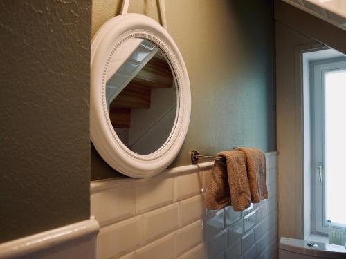 a bathroom with a mirror and towels on a rack at Sportsmen´s Holiday House in Otepää