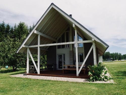 a small green house with a large porch at Sportsmen´s Holiday House in Otepää