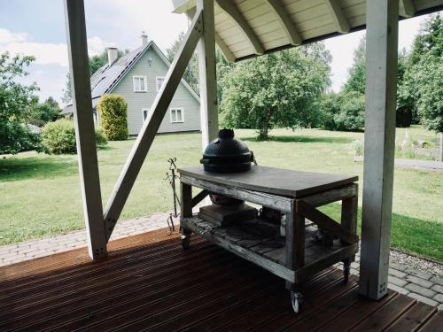a table on a porch with a bell on it at Sportsmen´s Holiday House in Otepää