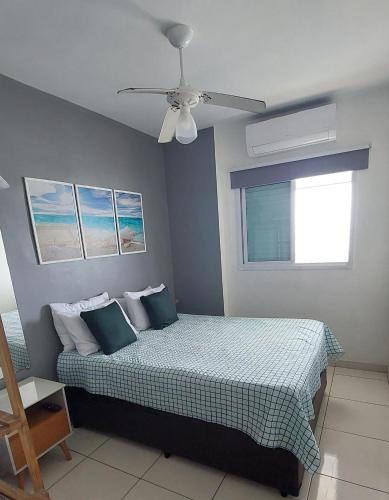 ein Schlafzimmer mit einem Bett und einem Deckenventilator in der Unterkunft Amor e aconchego beira mar e ar condicionado in Solemar