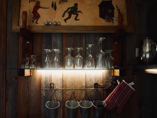 a shelf filled with glasses and bottles on a wall at Sportsmen´s Holiday House in Otepää
