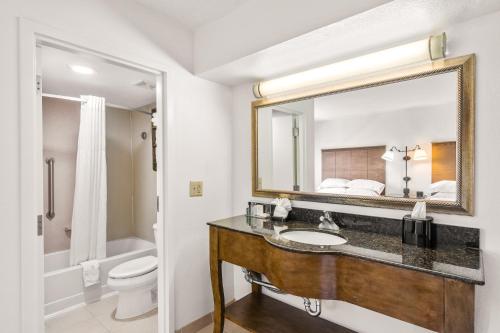 a bathroom with a sink and a toilet and a mirror at Hotel Alice in Atlantic Beach