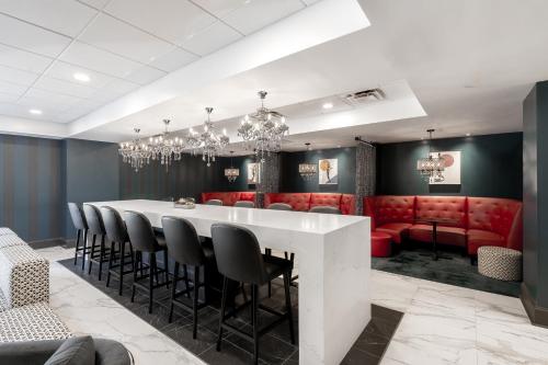 a dining room with a white table and red chairs at Hotel Alice in Atlantic Beach