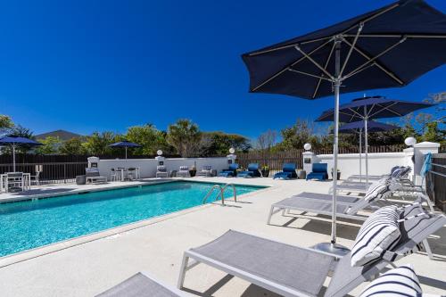 a swimming pool with chairs and umbrellas next to a pool at Hotel Alice in Atlantic Beach
