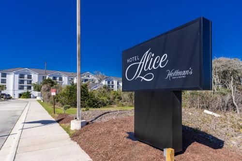 a sign for a hotel with a building in the background at Hotel Alice in Atlantic Beach