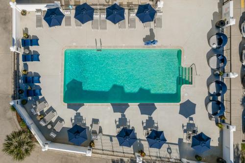 an overhead view of a swimming pool with blue umbrellas at Hotel Alice in Atlantic Beach