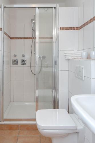 a bathroom with a shower and a toilet and a sink at Vik1_17 in Westerland