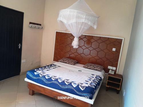 a bedroom with a bed with a canopy at Pearl Motel Wing in Mukono