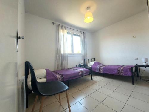 une chambre avec deux lits et une chaise et une fenêtre dans l'établissement 66m2 ok animaux chéques vacances 2ch wifi 2km mer soleil catalan, à Latour-Bas-Elne