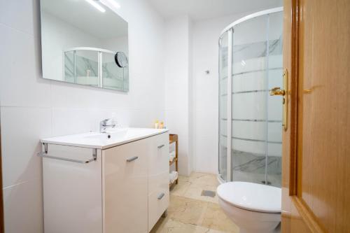 a bathroom with a toilet and a sink and a shower at La Fonda del Arco in Guadix