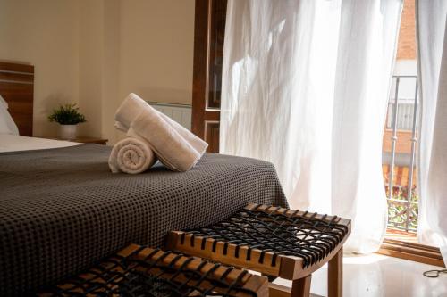 a bedroom with a bed and a large window at La Fonda del Arco in Guadix