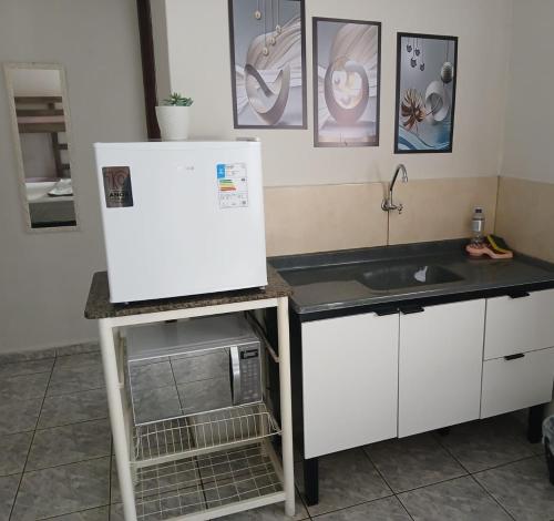 a kitchen with a sink and a refrigerator at Pousada Ebenezer in Andradina