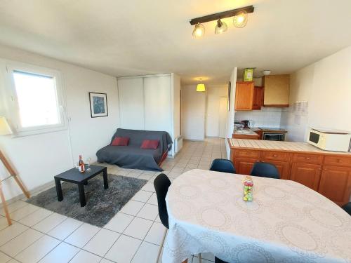 Il dispose d'une cuisine et d'un salon avec une table et un canapé. dans l'établissement 66m2 ok animaux chéques vacances 2ch wifi 2km mer soleil catalan, à Latour-Bas-Elne