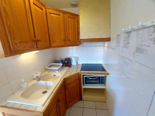 une petite cuisine avec un évier et un micro-ondes dans l'établissement 66m2 ok animaux chéques vacances 2ch wifi 2km mer soleil catalan, à Latour-Bas-Elne