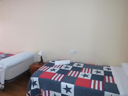 a bedroom with two beds and a quilt with stars at SAN PEDRO 64 vut in Lugo