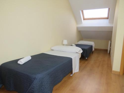 two beds in a small room with a window at SAN PEDRO 64 vut in Lugo