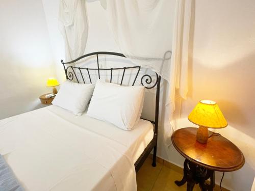 a bedroom with a bed and a table with a lamp at Argo-Milos in Adamas